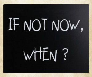 "If not now, when?" handwritten with white chalk on a blackboard